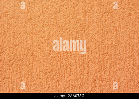 Fragment of a plastered wall of orange color with a fine texture. For use as an abstract background. Stock Photo