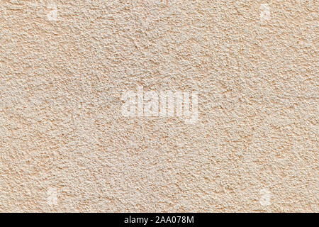 Fragment of a beige plastered wall with a fine texture. For use as an abstract background. Stock Photo