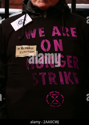 London, UK. 18th November 2019. Member of the environmental action group Extinction Rebellion seen in front of the Conservative Party headquarters in Westminster, London, with a hunger strike T-shirt, starting a week of fasting in solidarity of people starving because of climate change and ecological breakdown. Credit: Joe Kuis / Alamy News Stock Photo