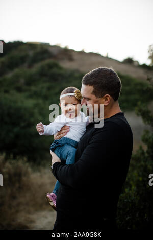 Dad Holding Infant Daughter as Baby Smiles Stock Photo