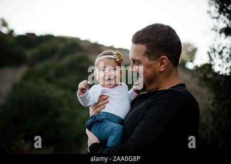 Dad Holding Infant Daughter as Baby Smiles Stock Photo