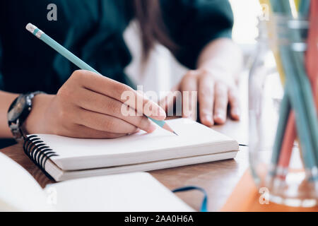 Close up female hands with pen writing on notebook. Education concept. Stock Photo