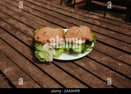 Sandwich with Hum and salad on a wooden bench Stock Photo