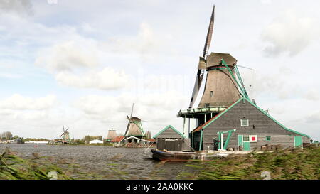 AMSTERDAM, NETHERLANDS-OCTOBER, 12, 2017: windblown reeds and windmills at zaanse schans near amsterdam Stock Photo