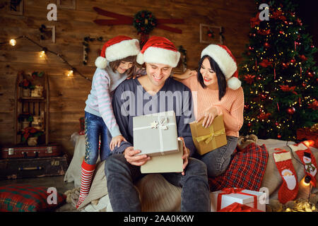 Excited parents with girl opening Xmas gifts Stock Photo