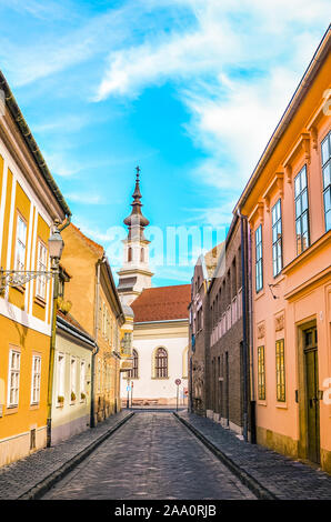 Old town street and buildings in the historical center of Budapest, Hungary. Lutheran Church of Budavar in the background. The beautiful historical center of the Hungarian capital city. Stock Photo