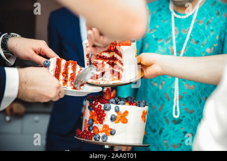 Handing out a wedding cake with berry filling to people with shallow depth of field Stock Photo