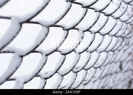 Mesh fence lattice crushed by snow close up Stock Photo