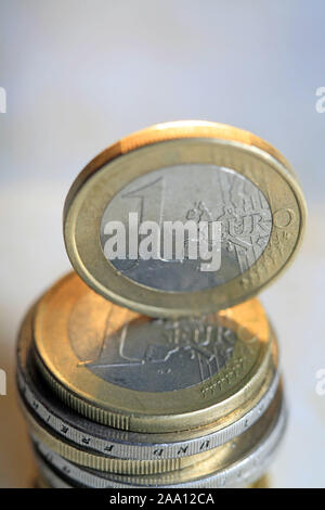 Ein Euro Stück steht auf einem Stapel Euro Münzen / One Euro coin is standing up to a pile of Euro coins Stock Photo