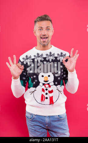 Fashion design for keeping festive. Happy man give OK sign in snowman jumper. Cold weather male style and fashion. Fashion trends for holiday celebration. Take fashion outfit to party level. Stock Photo