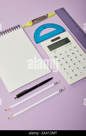 rulers and calculator near notebook and stationery isolated on purple Stock Photo