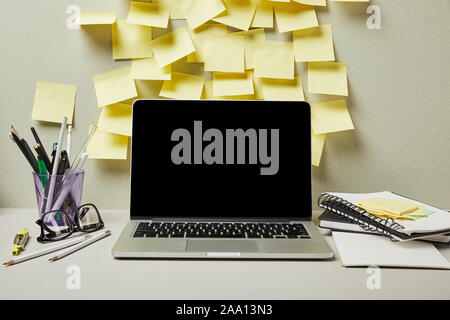 laptop with blank screen near empty sticky notes and stationery on grey and white Stock Photo