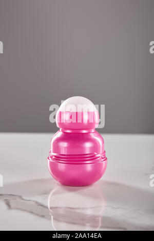 roll on pink bottle of deodorant on marble table isolated on grey Stock Photo