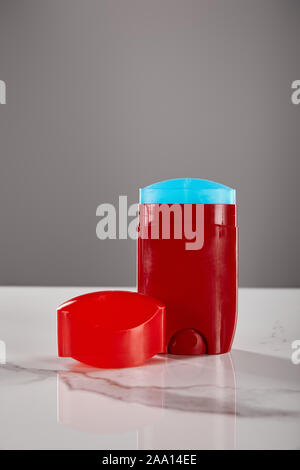 red roll on bottle of deodorant on marble table isolated on grey Stock Photo