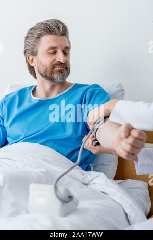 cropped view of doctor measuring blood pressure of patient in hospital Stock Photo
