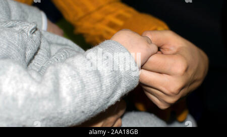 Close-up of mother holding child's hand Stock Photo
