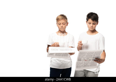 two serious boys reading newspapers while holding coffee cups isolated on white Stock Photo