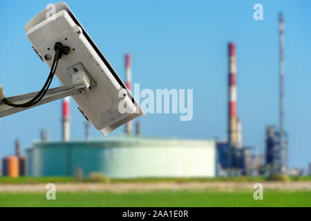 CCTV camera concept with fuzzy oil storage tanks on blurry background Stock Photo