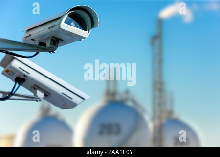 CCTV camera concept with refinery on blurry background Stock Photo