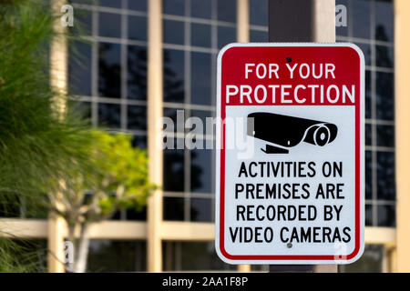 Santa Ana, CA / USA – November 14, 2019: A video surveillance sign is posted in from of an office building in the city of Santa Ana, California. Stock Photo