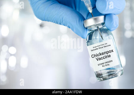 Healthcare concept with a hand in blue medical gloves holding Chicken pox, varicella-zoster virus, vaccine vial Stock Photo