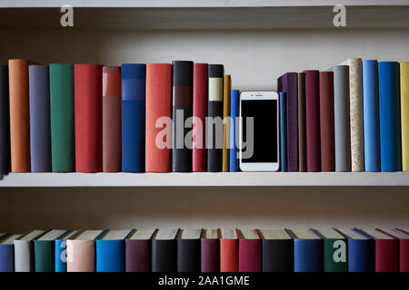 Accurate bookcase in an office with mobile phone Stock Photo