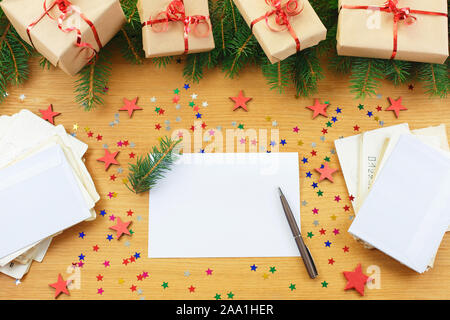 Christmas background with gift bags and blank notebook surrounded by Christmas decorations. Letter to Santa or Christmas shopping, wish list Stock Photo