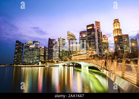 Stunning view of the Marina Bay skyline with beautiful illuminated skyscrapers during a breathtaking sunset in Singapore. Stock Photo