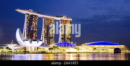 Stunning view of the Marina Bay skyline with beautiful illuminated skyscrapers during a breathtaking sunset in Singapore.