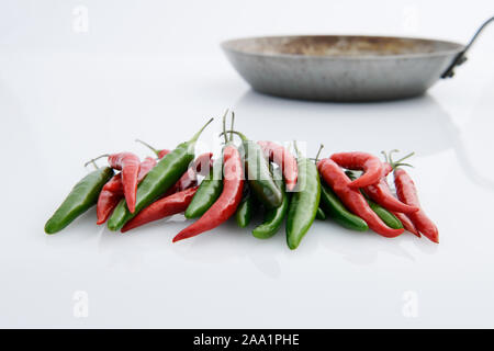 Close up, collection of red and green chilli peppers with frying pan, food preparation, home cooking, flavour, ingredient, still life Stock Photo