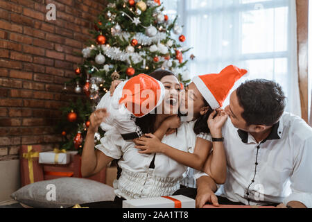 kids kiss their parent on a cheek Stock Photo