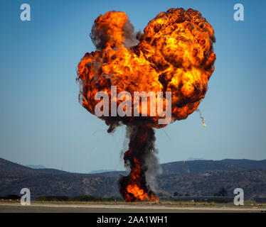 Heart shapped ball of fire and column of smoke from munitions explosion Stock Photo