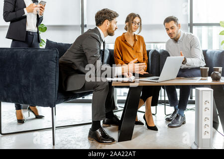 Young couple solving some financial issues with financial consultants at the luxury bank office. Investment or lending concept for a young family Stock Photo