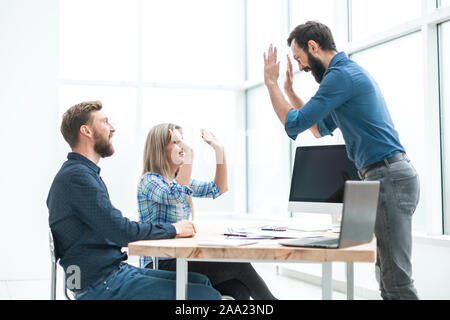 friends co-workers giving each other a high five Stock Photo