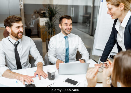 Two exhausted employees during a business conference with a team leader in the meeting room Stock Photo