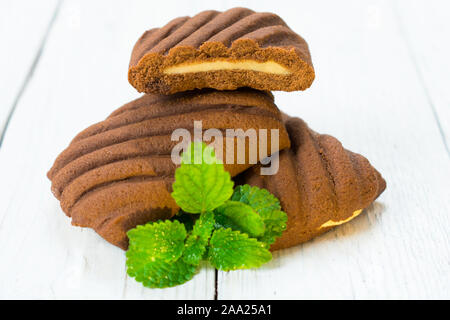 Chocolate cookies with mint filling on a white wooden background. Copy space. Stock Photo