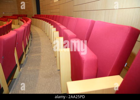 Red seats in the auditorium quietly and without people . Rows of red velvet theater seats in an old Vaudeville style theater. Empty red seats for Stock Photo