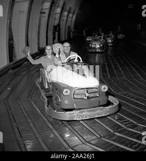 Amusement park in the 1940s. An elderly man with a young girl, possibly his granddaughter is driving a go-cart on the electric track at Gröna Lund amusement park i Stockholm Sweden. Sweden May 31 1958. ref 3760 Stock Photo