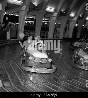 Amusement park in the 1940s. An elderly man with a young girl, possibly his granddaughter is driving a go-cart on the electric track at Gröna Lund amusement park i Stockholm Sweden. Sweden May 31 1958. ref 3760 Stock Photo