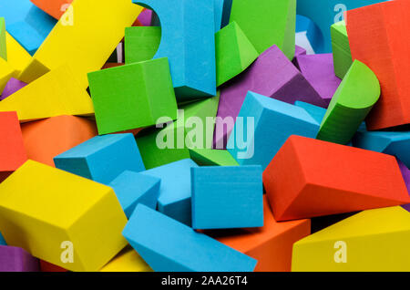 Different shape wooden toy blocks. Colorful background of red, yellow, green, blue, purple toy blocks. Stock Photo