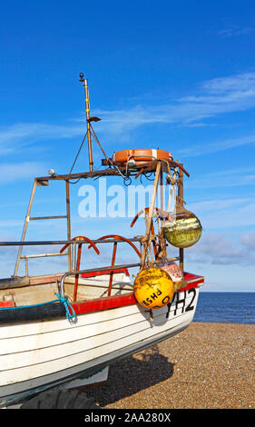 The stern of an inshore fishing boat with buoys and anchors on a North Norfolk beach at Cley-next-the-Sea, Norfolk, England, United Kingdom, Europe. Stock Photo
