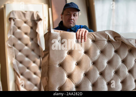 Belarus, the city of Gomil on April 29, 2019. Wood processing plant.Worker in the workshop for the production of beds. The master makes luxury furnitu Stock Photo