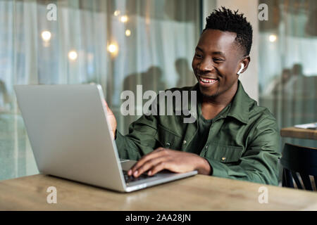 Handsome african american man using computer and smiling. young businessman recording video for online webinar using laptop Stock Photo