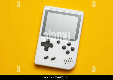 Old game console. Gamepad is white on a yellow background. Stock Photo