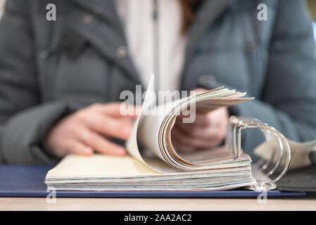 Buyer is choosing a products in a store catalog close up. Stock Photo