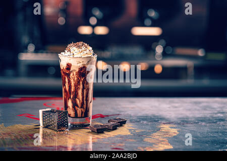 Fancy latte coffee in glass with chocolate syrup, copy space Stock Photo
