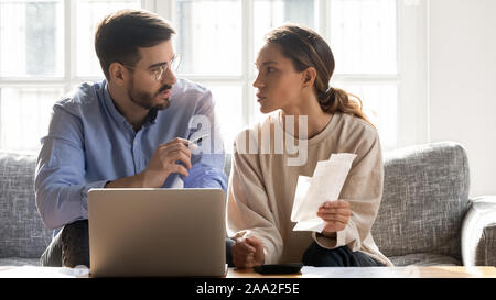 Focused married couple managing family monthly budget together. Stock Photo