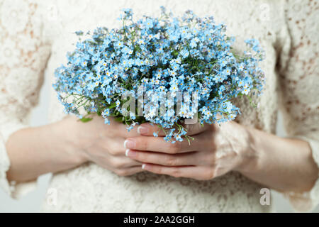 Blue flowers in female hands Stock Photo