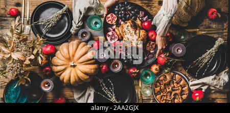 Thanksgiving table setting with roasted chicken and pie, wide composition Stock Photo