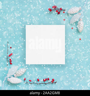 Christmas card or banner; White pine cones and red berries on blue background Stock Photo